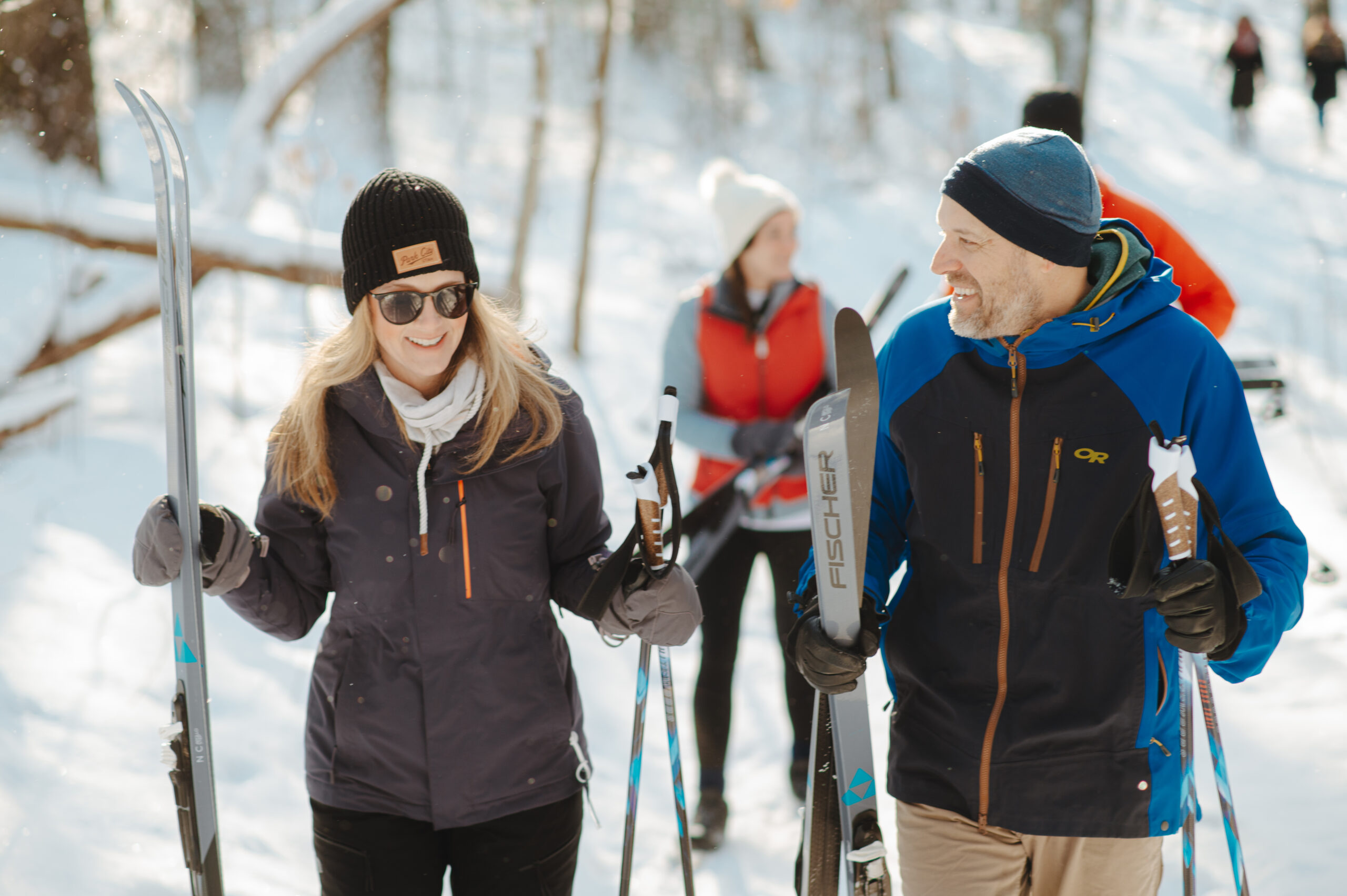 Two people smiling and cross country skiing at Saugatuck Dunes State Park.