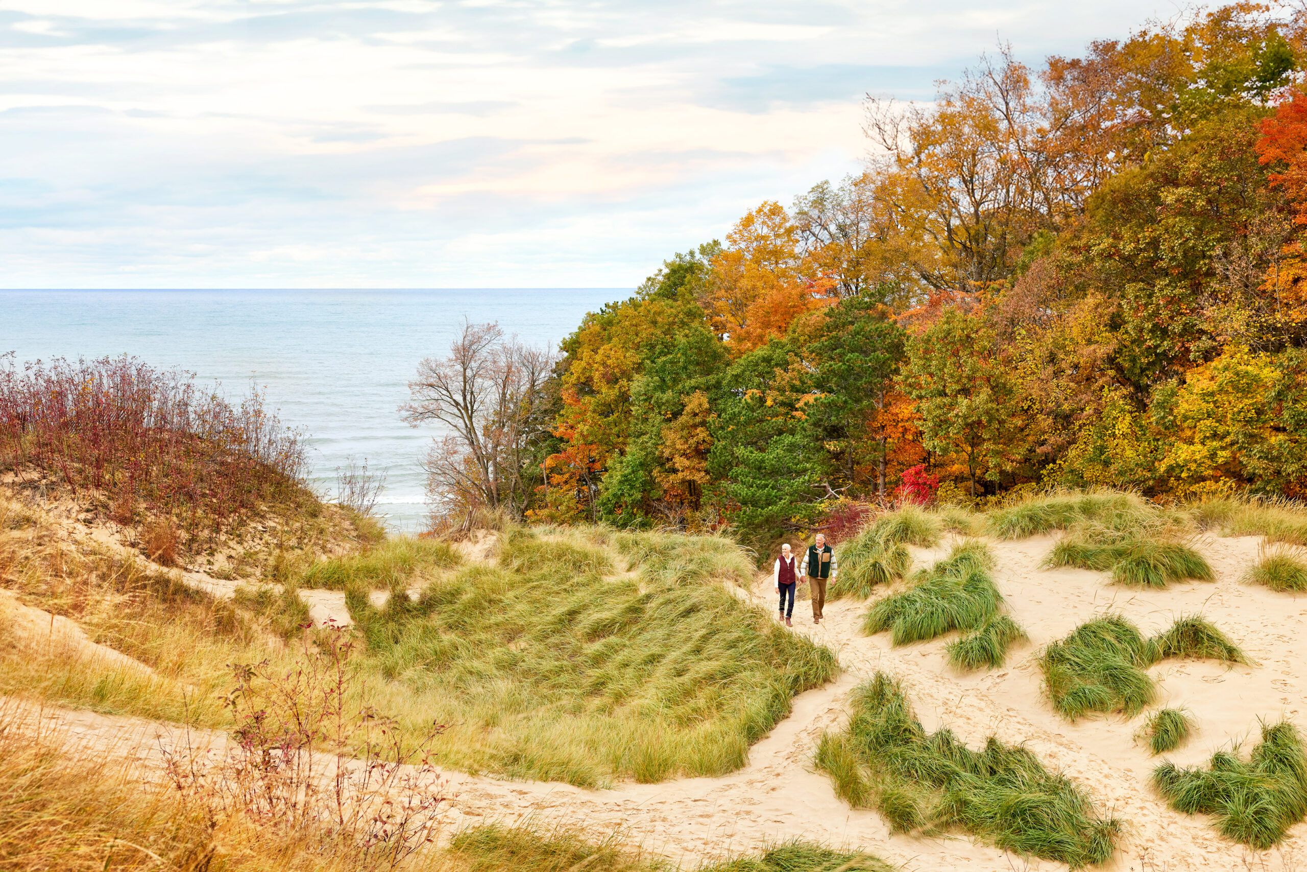 A couple walking the hills of Laketown Beach in the fall.