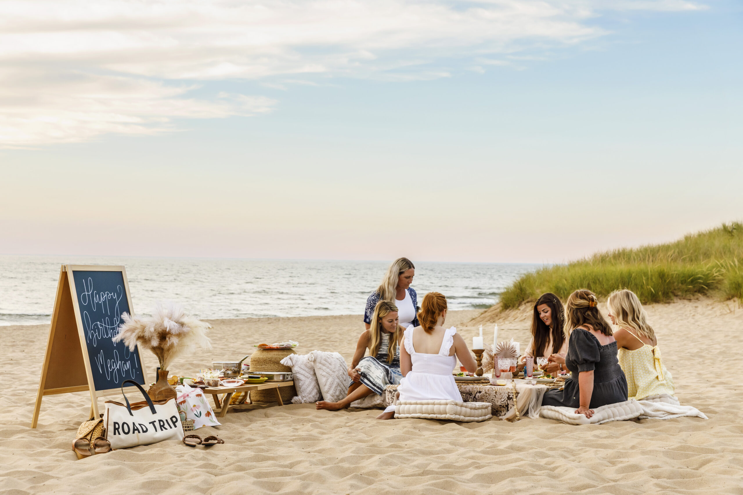 A group of girlfriends enjoying a luxury picnic on the shores of Oval Beach.