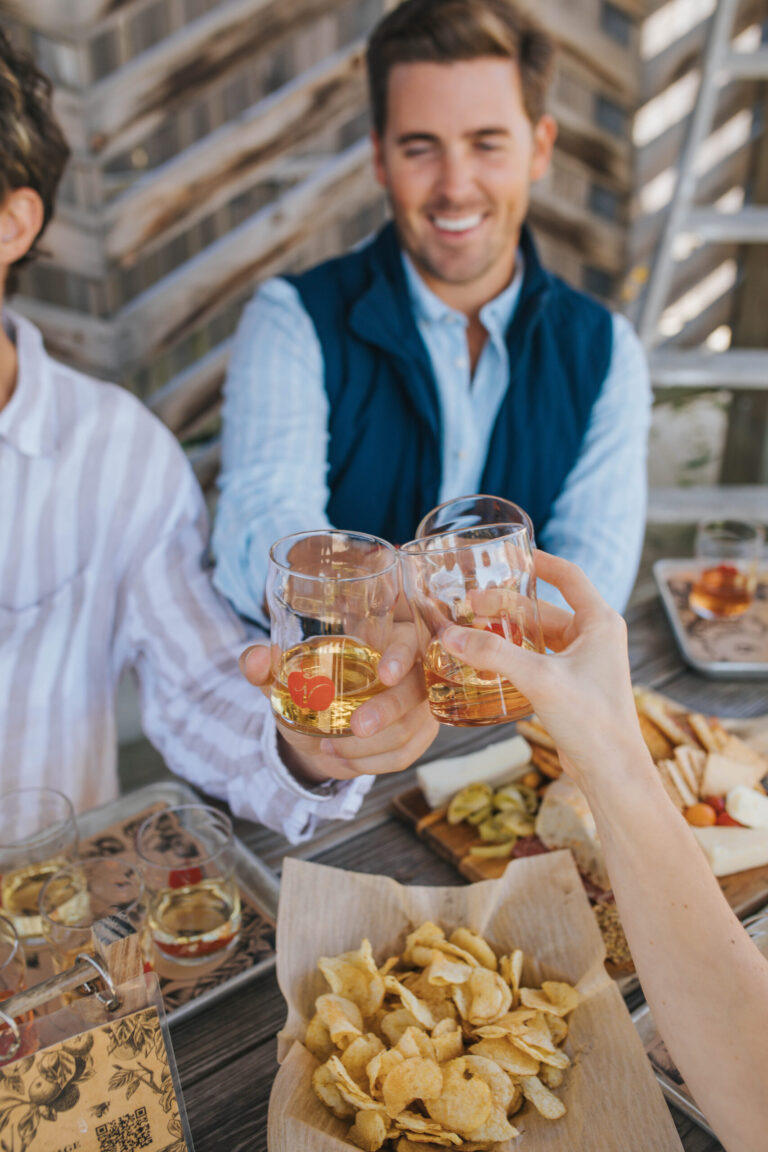 Two men toasting over food and drinks.