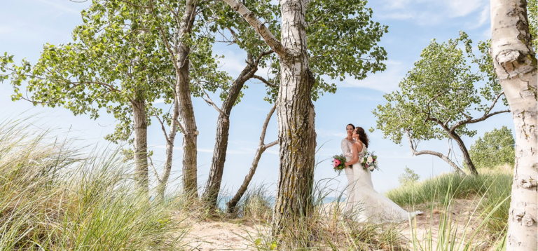 Two brides hugging on the beach.