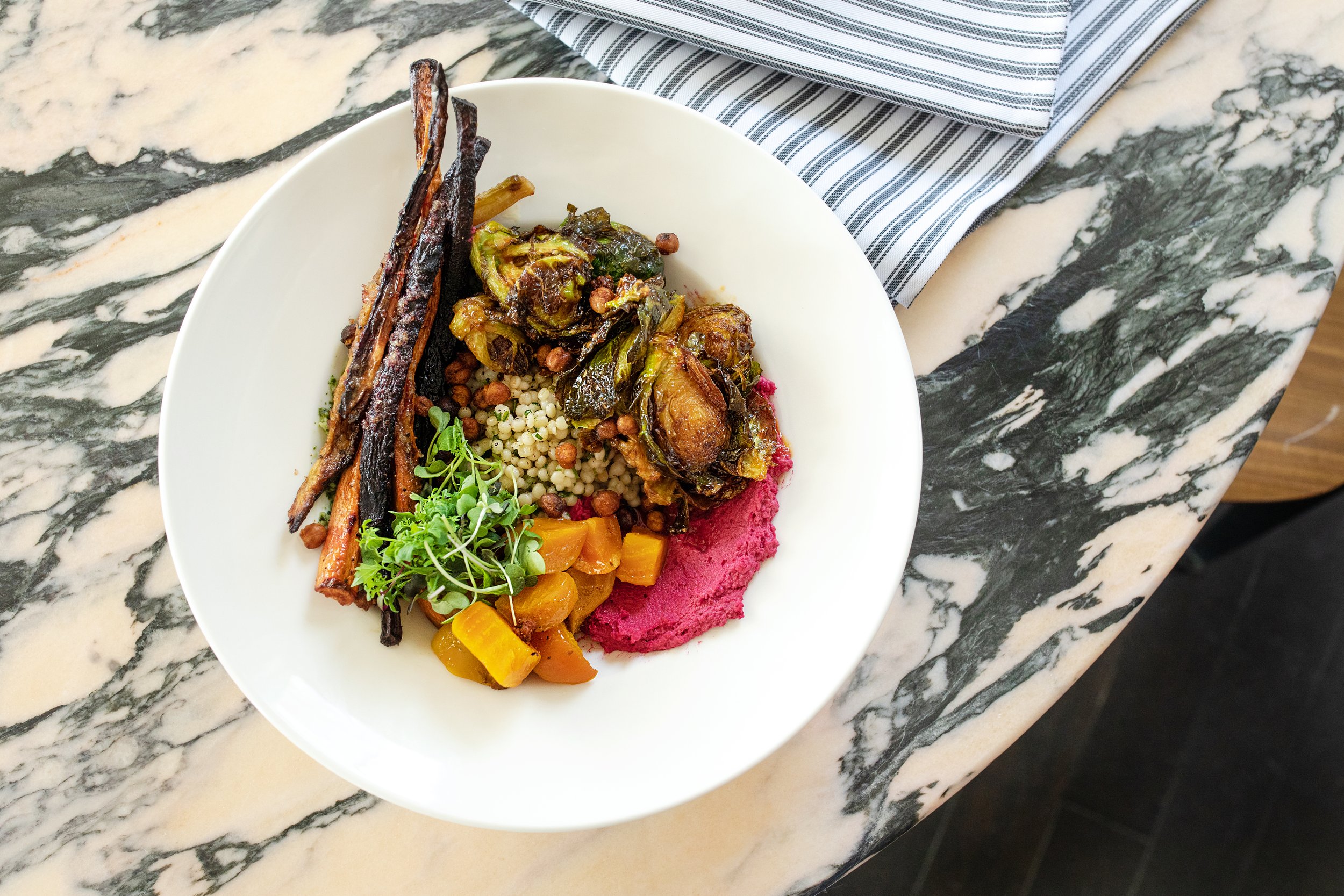 Colorful plate of vegetables on a marble table.