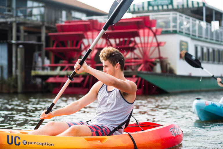 Man kayaking down channel, Star of Saugatuck is in the background.